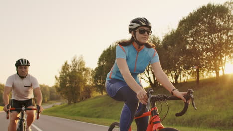 Hartes-Training.-Zwei-Triathleten-Trainieren-Auf-Dem-Rennrad.-Zwei-Radfahrer-Fahren-Auf-Dem-Rennrad-Im-Stadtpark-Und-Bereiten-Sich-Auf-Den-Triathlon-Vor.-Intensives-Training-Für-Fitte-Athleten.-Zwei-Männer-Und-Eine-Frau-Fahren-Vor-Dem-Triathlon-Wettkampf-Rad.